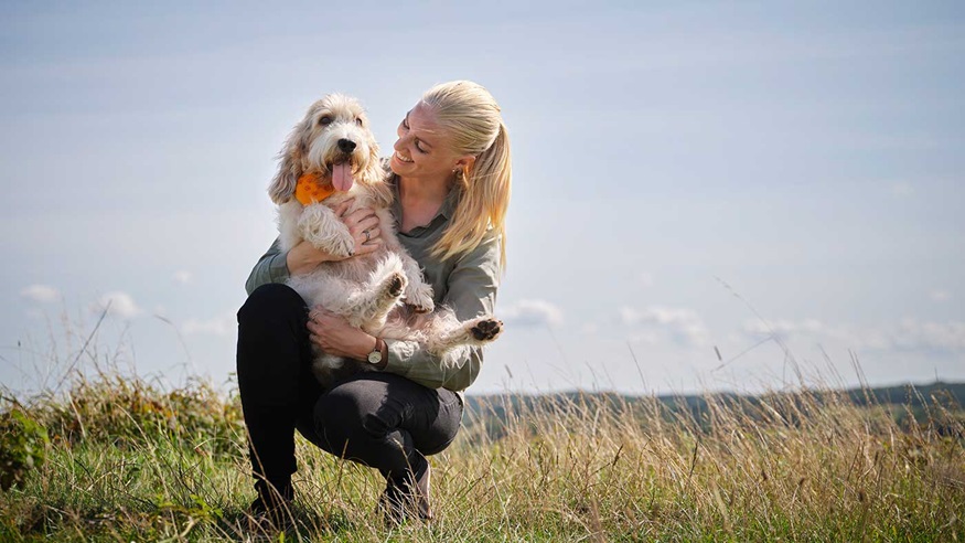 Sanne og hendes hund Elvis på en mark